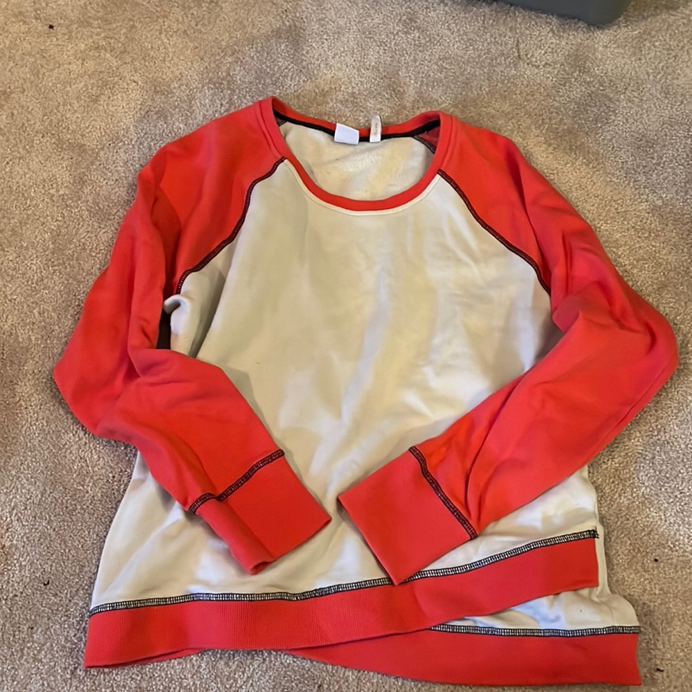 Cinch Pullover hoodie. Coral arms and cream. Has thumb holes in the arms.